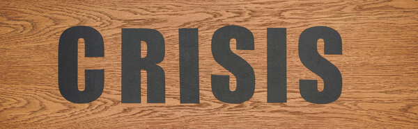 верхний вид черной бумаги сократить слово кризис на деревянной поверхности, панорамный снимок
