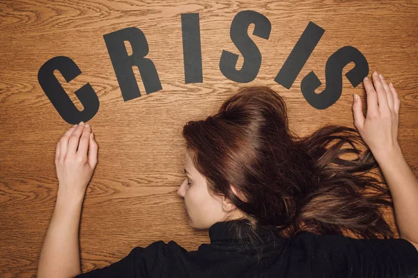 Top View Unconscious Woman Lying Face Word Crisis Wooden Floor — Stock Photo, Image