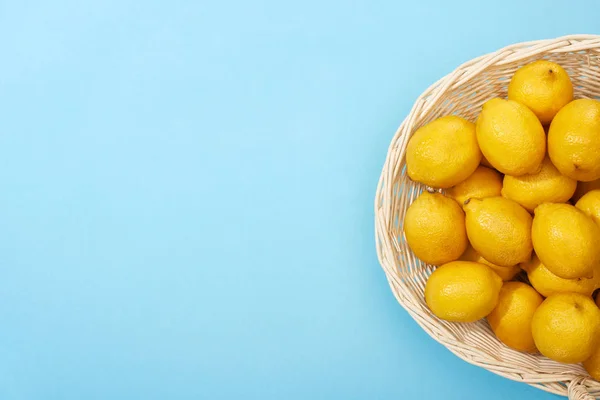 Horní Pohled Zralé Žluté Citrony Proutěném Koši Modrém Pozadí Kopírovacím — Stock fotografie