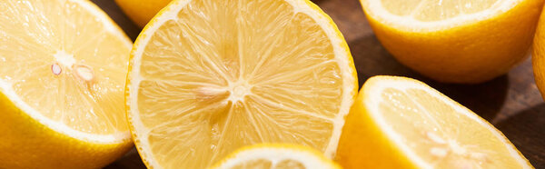 close up view of ripe cut lemons on wooden cutting board, panoramic shot