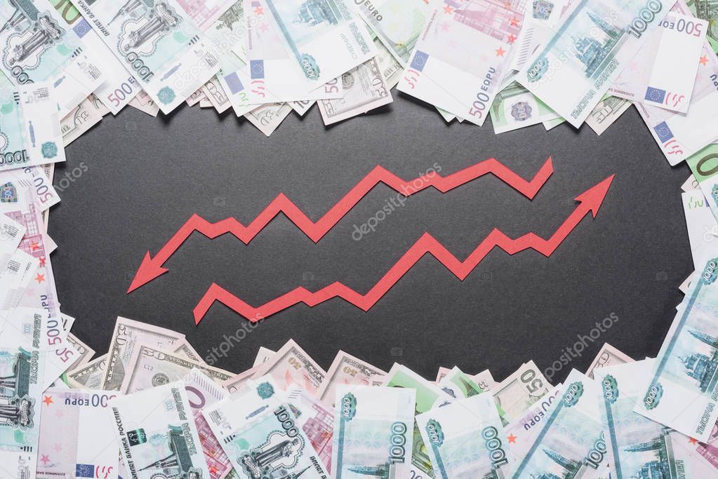 increase and recession arrows in frame of dollar, euro and ruble banknotes on black background