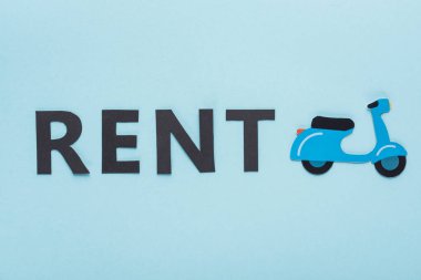 Kağıt kesme mobiletinin üst görünümü ve mavi arkaplanda kira harfleri