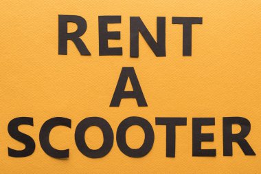 Kağıt kesikli araba ve turuncu arkaplandaki siyah kira harflerinin fotokopi alanı ile üst görünümü