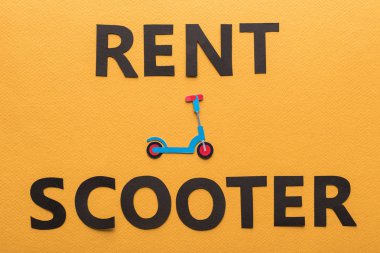 Kağıdın üst görünümü turuncu arkaplanda kira scooter harfleri