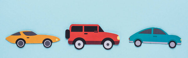 top view of paper cut various cars on blue background, panoramic shot