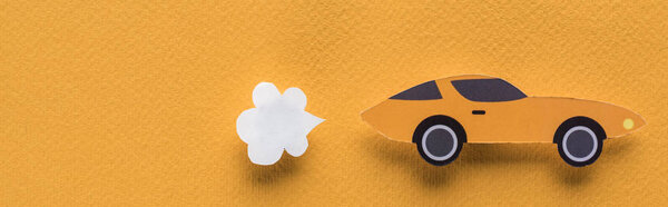 top view of paper cut sports car with exhaust gas on orange background, car rent concept, panoramic shot