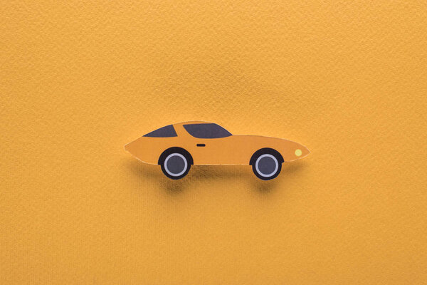 top view of paper cut sports car on orange background, car rent concept