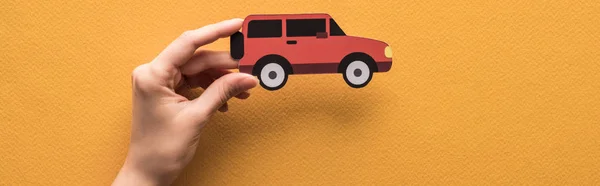 Vista Ritagliata Della Donna Possesso Carta Tagliata Auto Sfondo Arancione — Foto Stock