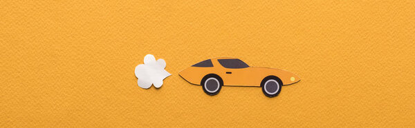 top view of paper cut sports car with exhaust gas on orange background, panoramic shot