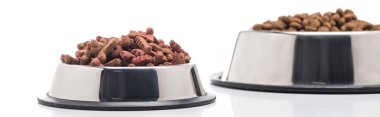 selective focus of assorted dry pet food in bowls isolated on white, panoramic shot clipart