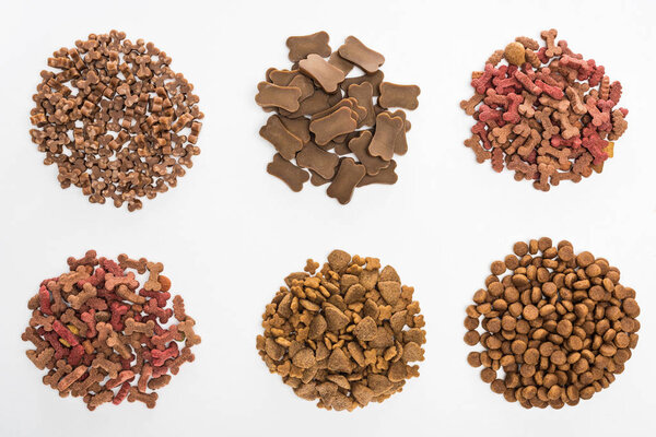 top view of assorted dry pet food in piles isolated on white