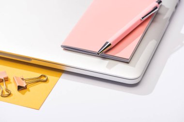 yüksek açılı dizüstü bilgisayar, kağıt, defter, kalem ve ataç görünümü 
