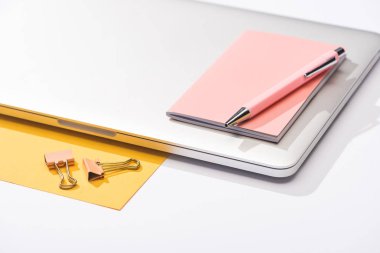 yüksek açılı dizüstü bilgisayar, kağıt, defter, kalem ve ataç görünümü 