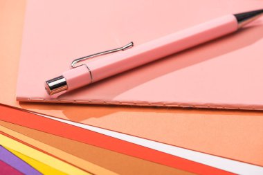 parlak ve renkli kağıtlar üzerine seçici kalem ve defter odağı 