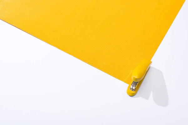 Visão Alto Ângulo Grampeador Papel Amarelo Sobre Fundo Branco — Fotografia de Stock