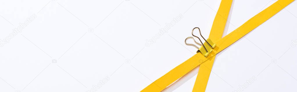 panoramic shot of binder clip and paper strips on white background 