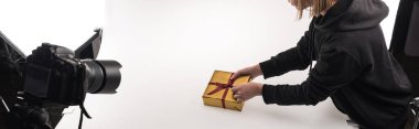 Fotoğraf stüdyosunda fotoğrafçının noel fotoğraflarını dijital kamerada, beyazda fotoğraf stüdyosunda, panoramik çekimde çekerken görüntülenmiş.