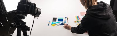 Beyaz panoramik çekimler için ofis malzemeleriyle yatarken çekilmiş fotoğrafçı görüntüsü.