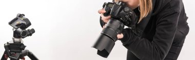 Beyaz üzerine izole edilmiş dijital kamerayla çalışan ticari fotoğrafçının kırpılmış görüntüsü