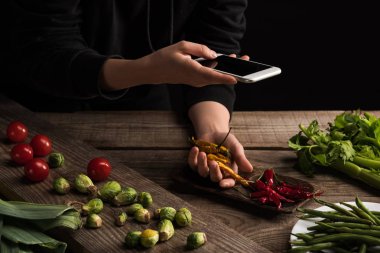 Fotoğrafçının ticari fotoğrafçılık için ahşap masadaki akıllı telefondan yemek kompozisyonu oluşturduğu görüntüler.