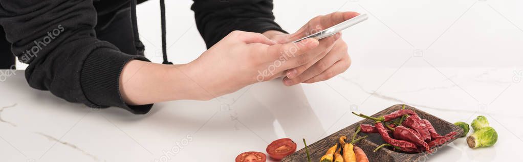 cropped view of female photographer making food composition for commercial photography on smartphone