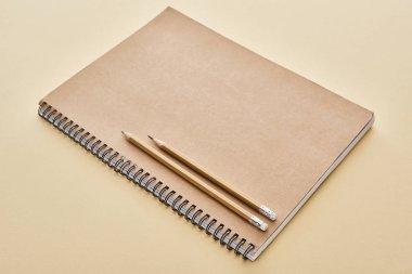 paper blank notebook with pencils on beige background clipart