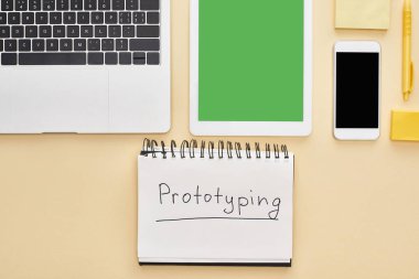 Aletlerle yatıyordu ve sarı arka plandaki not defterinde prototip harfleri vardı.