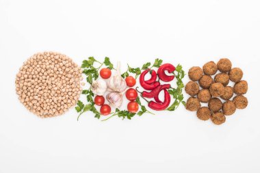 Beyaz arka planda nohut, sarımsak, kiraz domates, maydanoz, kırmızı biber ve falafel manzarası.