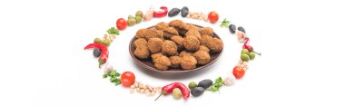 Nohut, sarımsak, kiraz domatesleri, maydanoz, zeytin, kırmızı biber, yeşil soğan yuvarlak çerçeveli, beyaz arkaplanda falafel topları, panoramik çekim