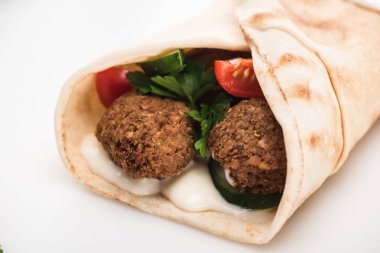 Pide 'deki taze falafel toplarının beyaz arka planda sebze ve sos manzarasını kapat.