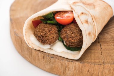 Pide 'deki taze falafel köfteleri, sebzeler ve ahşap tahtadaki beyaz arka plandaki sos manzarasını kapat.