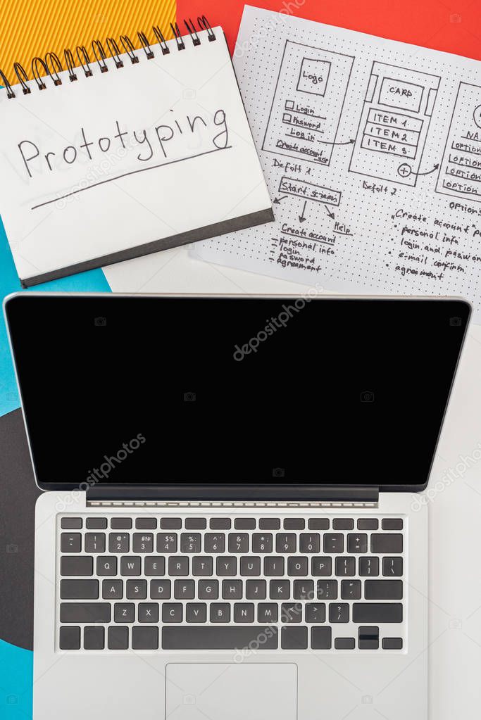 top view of notebook with prototyping lettering, laptop and website design template on abstract geometric background