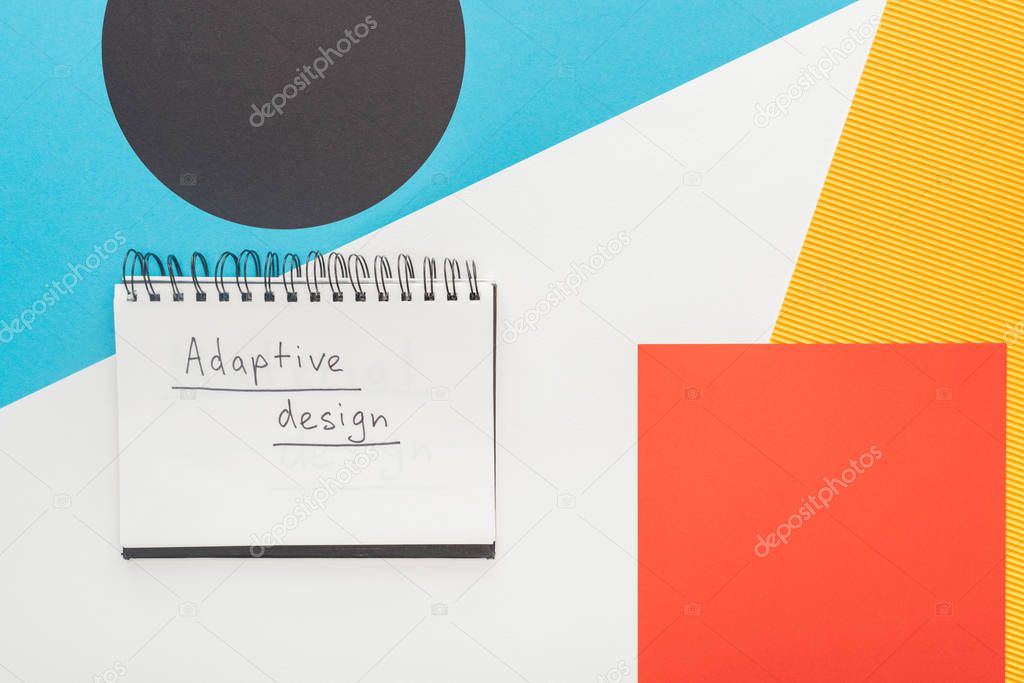 top view of notebook with adaptive design lettering on abstract geometric background