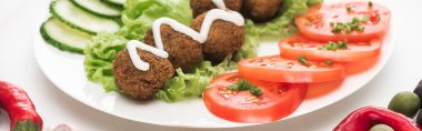Beyaz arka planda dilimlenmiş sebzelerle soslu falafel manzarasını kapat, panoramik çekim
