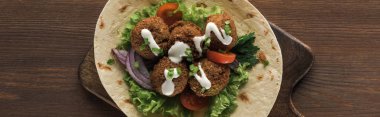Sebzeli falafel ve ahşap masadaki pide sosu, panoramik çekim