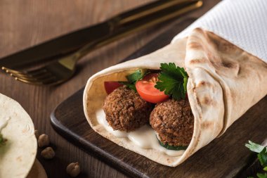 Sebzeli falafel manzarası ve ahşap masadaki pide sosu kapat.