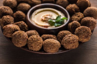 Tahta tabakta humus olan falafel toplarının yakın görüntüsü.