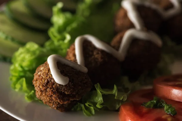 Zblízka Pohled Falafel Omáčkou Talíři Nakrájenou Zeleninou Tmavé — Stock fotografie