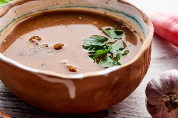 Close up view of soup kharcho with cilantro and garlic on table