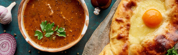 Top view of soup kharcho with cilantro and adjarian khachapuri, panoramic shot