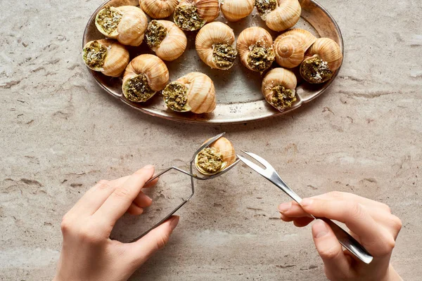 Gedeeltelijk Uitzicht Vrouw Eten Heerlijke Gekookte Escargots Met Pincet Stenen — Stockfoto