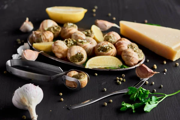 Selective Focus Delicious Cooked Escargots Lemon Slices Cutlery Black Peppercorn — Stock Photo, Image