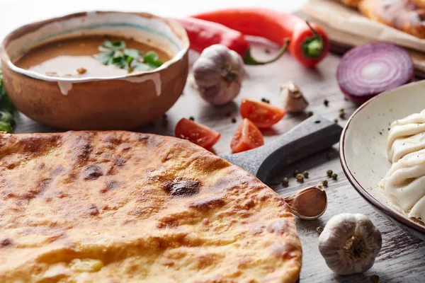 Imereti khachapuri, khinkali and soup kharcho on table with vegetables — Stock Image Imereti Khachapuri Khinkali Soup Kharcho Table Vegetables Stock Image