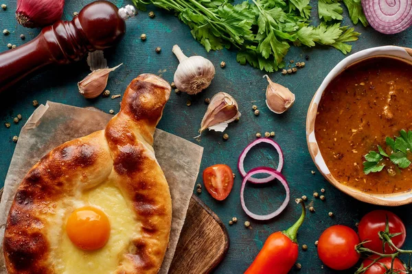 Top view of soup kharcho and adjarian khachapuri with spices and vegetables on textured green background — Stock Image Top View Soup Kharcho Adjarian Khachapuri Spices Vegetables Textured Green Royalty Free Stock Photos