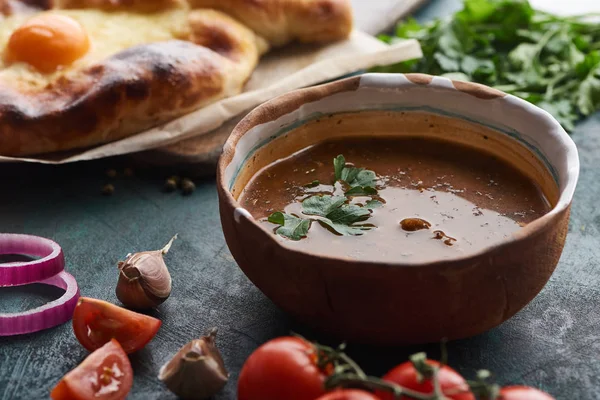 Soup kharcho with cilantro and adjarian khachapuri at background — Stock Image Soup Kharcho Cilantro Adjarian Khachapuri Background Stock Photo