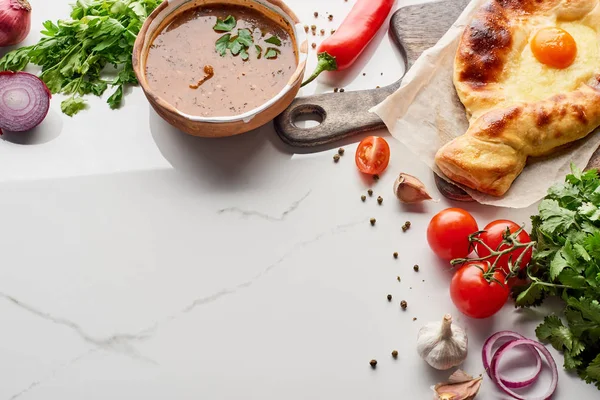 Adjarian khachapuri and soup kharcho with vegetables on marble texture — Stock Image Adjarian Khachapuri Soup Kharcho Vegetables Marble Texture Royalty Free Stock Photos