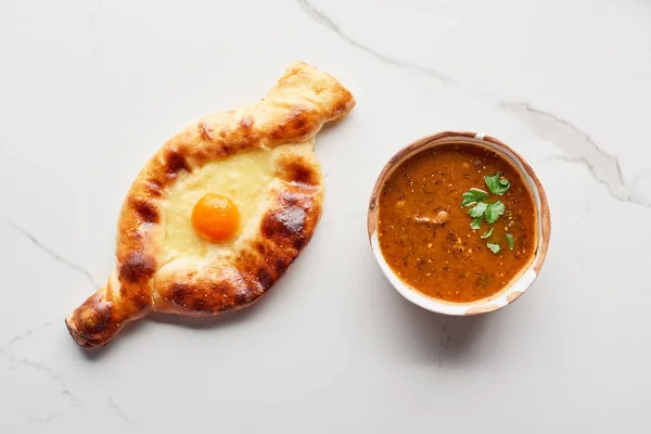 Top view of adjarian khachapuri and soup kharcho on marble texture — Stock Image Top View Adjarian Khachapuri Soup Kharcho Marble Texture Stock Photo