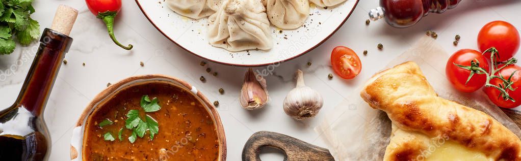 Adjarian khachapuri, soup kharcho, wine bottle and khinkali on marble texture, panoramic shot — Stock Image Adjarian Khachapuri Soup Kharcho Wine Bottle Khinkali Marble Texture Panoramic Stock Picture