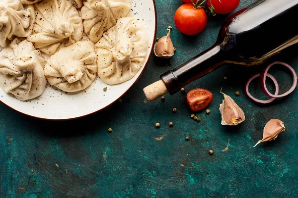 Top view of delicious khinkali and bottle of wine on green background — Stock Image Top View Delicious Khinkali Bottle Wine Green Background Stock Photo