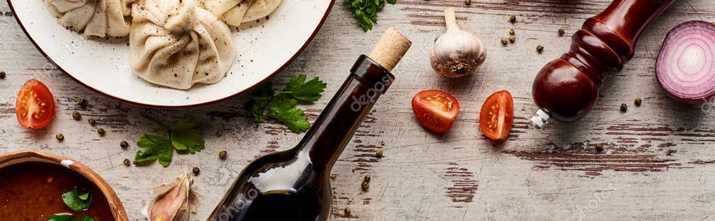 Top view of delicious khinkali near bottle of wine, kharcho, vegetables and spices on wooden table, panoramic shot — Stock Image Top View Delicious Khinkali Bottle Wine Kharcho Vegetables Spices Wooden Royalty Free Stock Images